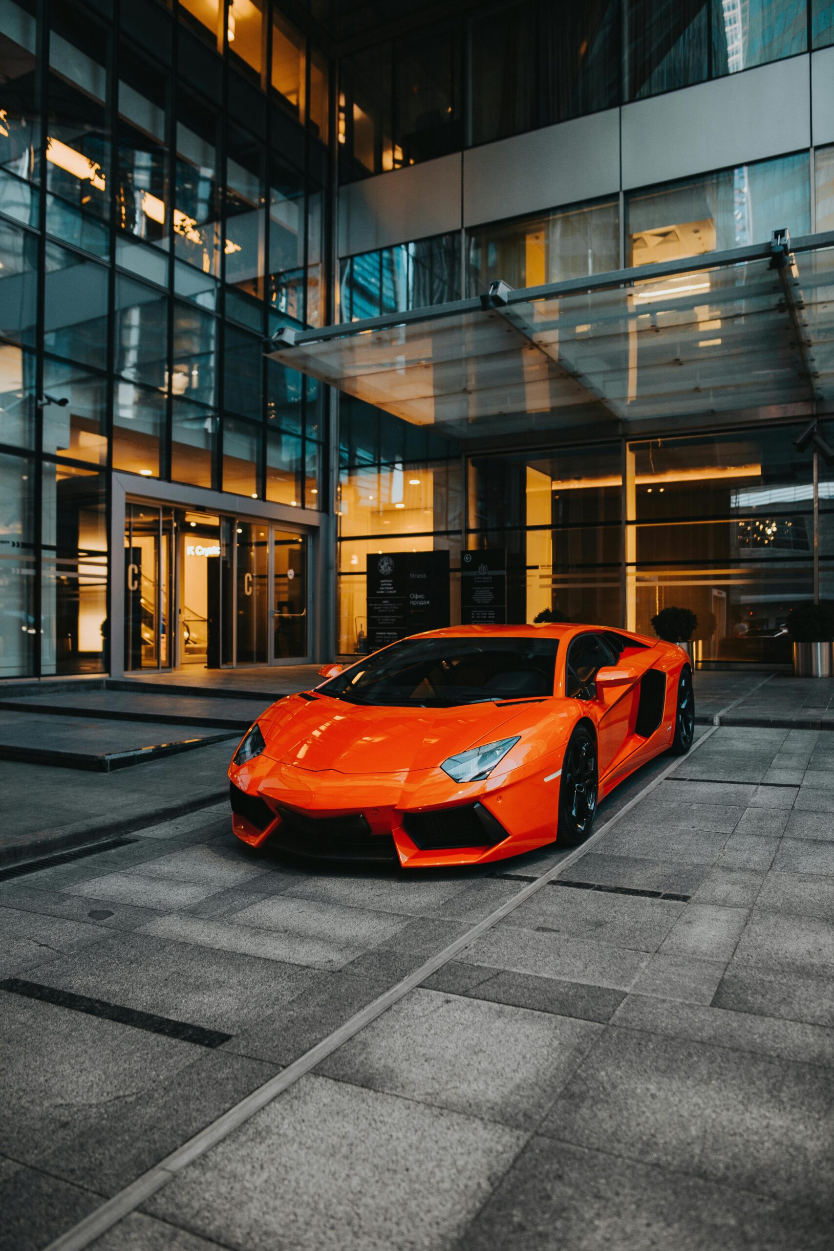 Dynamic shot of a Lamborghini Aventador parked in a modern architecture backdrop.